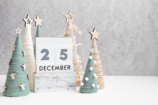Christmas craft background with calendar and handmade yarn cone xmas trees in natural colors.  DIY organic sustainable christmas decoration