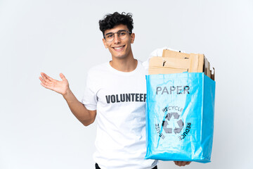 Young man holding a recycling bag full of paper with shocked facial expression