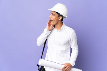 Young architect man isolated on background shouting with mouth wide open to the side