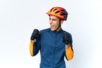 Young cyclist man isolated on background celebrating a victory