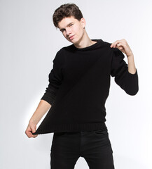 Handsome Fashion Man In Black Sweatshirt Posing On White Background. Model Test. Mock-up Sweatshirt. Fashion and people concept. stylish trendy young man dressed in casual clothes posing in studio