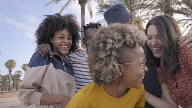 Group of friends having fun. Young people making friendly jokes and laughing. Cheerful multiethnic boys and girls enjoying being together on vacation.
