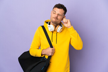 Young sport caucasian man with bag isolated purple background frustrated and covering ears
