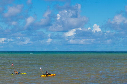 Dupla de pescadores com caiaque no mar.