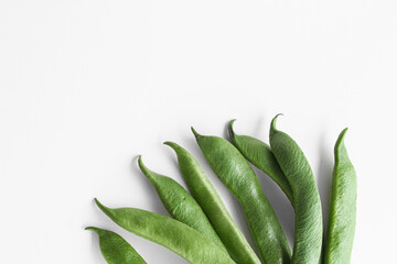 Green bean pods, spread out with fans. Space for text.