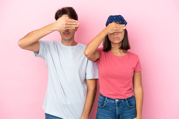 Young couple isolated on pink background covering eyes by hands. Do not want to see something