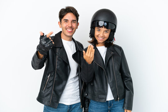 Young mixed race couple with a motorcycle helmet isolated on white background inviting to come with hand. Happy that you came