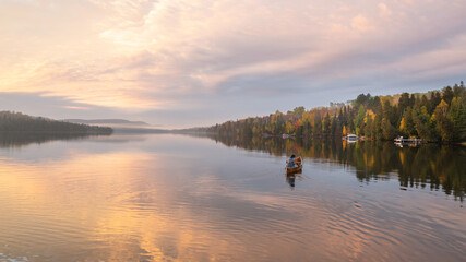 Fototapeta na wymiar People are boating on Caribou Lake on a fogy morning 