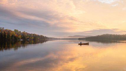People are boating on Caribou Lake on a fogy morning