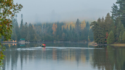 People are boating on Caribou Lake on a fogy morning	