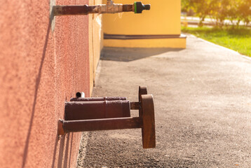Water hydrant on the wall of residential house. Safety, emergency, supply and industry concept photo