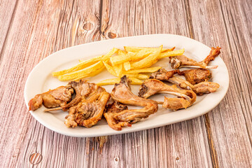 Tray of kid chops fried in olive oil with a garnish of homemade chips