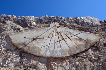 Horizontal shot of ancient sundial on the cliff