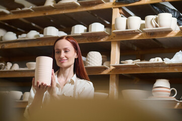 A cute young female potter in her workshop