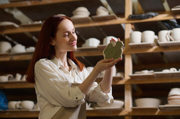 A young long-haired female potter in her workshop