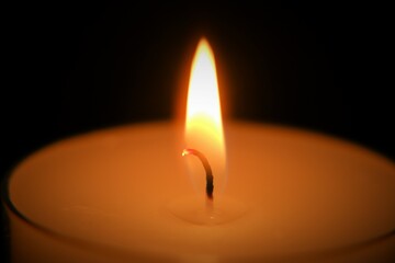 Candle on black background..Candle flame.Candle background. Burning candle in the dark