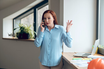 Young confident woman communicating by smartphone