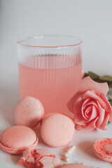 Pink macaron cookies and rose flowers on white background. French cookie. Soft pastel vintage tone. 