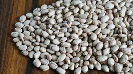 Beans. Portion of carioca beans on a rustic wooden table. Grain present in several dishes of Brazilian cuisine.