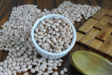 Obraz premium Bowl of beans. Pinto beans. Closeup of a ramekin with beans on wooden table with wooden spoon. Brazilian food.