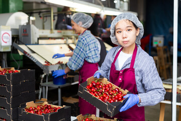 Group of female asian workers sorting cherry in warehouse