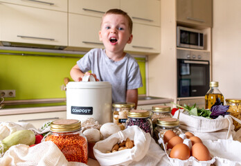 Child boy puts food waste in a compost bin. Waste sorting.