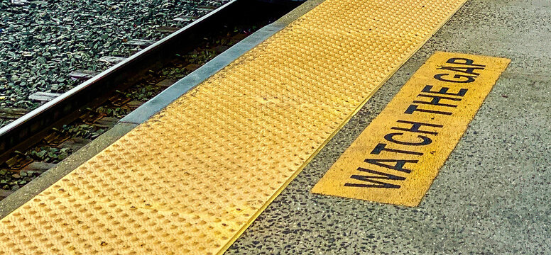 Watch the Gap safety or caution notice on train platform with textured yellow stripe and tracks. Use for retirement or savings insecurity, wage gap, diversity, inequity, college gap year 