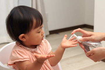 アルコール消毒をする子供