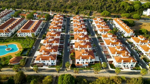 Aerial View Of Modern Tract Housing With Outdoor Pool On A Sunny Day In El Rompido, Spain.