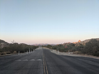 Joshua Tree National Park in California, United States. Trees and rocks on the dessert with the empty street in the middle