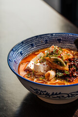 Spicy japanese miso tofu ramen with kimchi on restaurant table