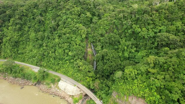 Catarata al frene de puente y rodeada de bosque, vista a&eacute;rea con drone