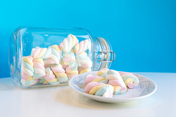 Closeup of rainbow marshmallows in a jar and in a plate - Powered by Adobe