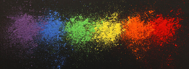 A wide banner background style shot of the LGQT rainbow flag colors made out of chalk dust and arranged in a line.