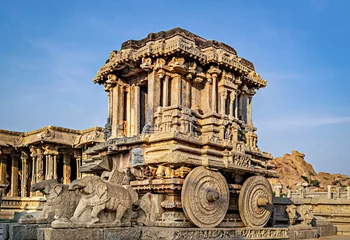 Zelfklevend Fotobehang Richly sculpted stone chariot with clear blue sky background in Hampi, Karnataka. © lalam