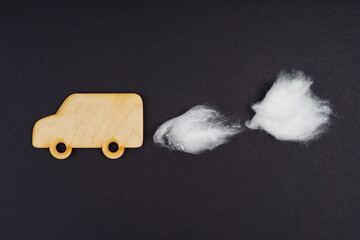 Wooden lorry with traces of CO-2 emissions - cotton wool. Isolated on a black background.