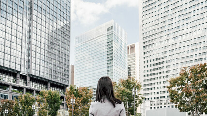 Fototapeta premium オフィス街にいるスーツ姿の女性（ビジネスイメージ）