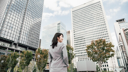 オフィス街にいるスーツ姿の女性（ビジネスイメージ）
