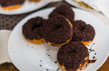 A stack of chocolate donut on white plate