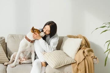 Young woman with her cute dog at home. Lovely pet