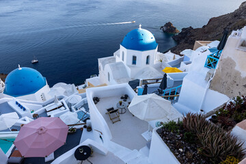 View from viewpoint of Oia village with blue domes of  greek orthodox Christian churches and traditional whitewashed greek architecture.  Santorini, Greece