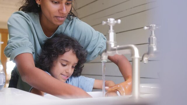 Slow motion of mother and son washing hands