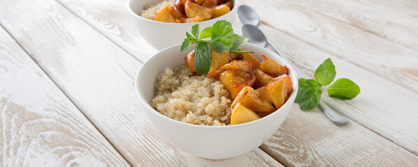 bowls of quinoa porridge with apples and cinnamon on a light wooden table