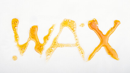 golden cannabis wax extract, lettering word on white background