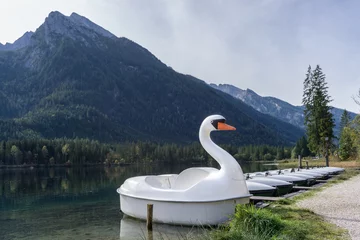 Schilderijen op glas many rental boats at a bridge on lake in the mountains with a swan boat © Sebastian