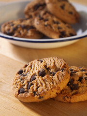chocolate chip cookies on a wooden table chocolate chip cookies on a pewter plate on a wooden table