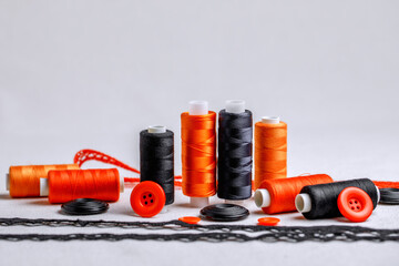 A set for creativity for Halloween in black and orange colors. Decorative threads, braid and buttons on sackcloth. Preparation for the holiday.
