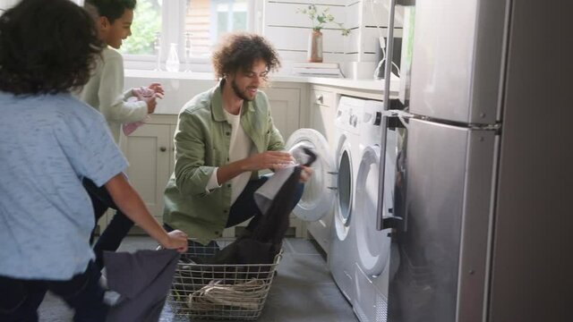 Slow motion of father doing laundry with sons