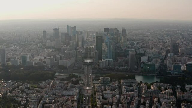Dolly forward drone shot of La Defence Paris Business District from Axe Historique road at sunset