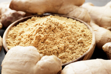 Dry and ground ginger on a wooden background. Dry ginger in a bowl. Ginger in a spoon. Cooking...